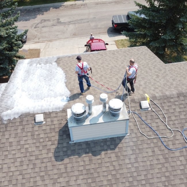 roof rejuvenating experts working on a roof in Calgary.
